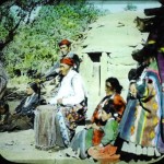 Navajo Medicine man sits in front of hogan with his family