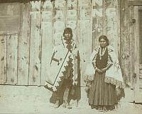 Navajo man and woman wearing rugs and standing in front of Warren Trading Post Co