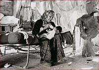 An elderly Navajo woman bottle feeding an infant